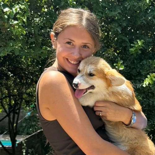 Persona abrazando a su cachorro Corgi